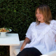 Elizabeth Heiskell relaxing outdoors while seated at a table with food.